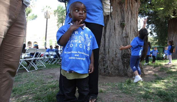 Peter Yabadi, 2, stands next to his mother