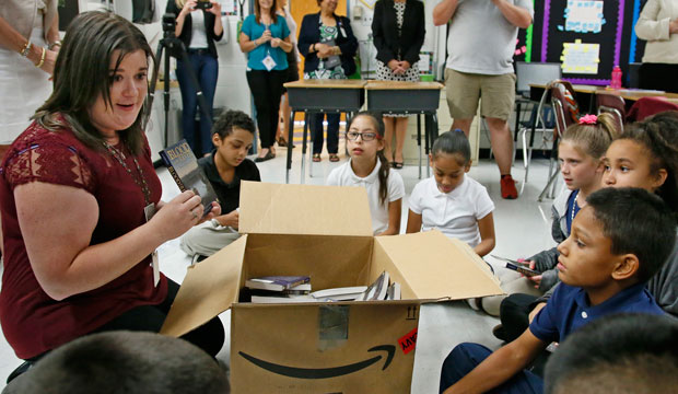 An Oklahoma City fifth-grade teacher passes out books to her class on August 3, 2016.